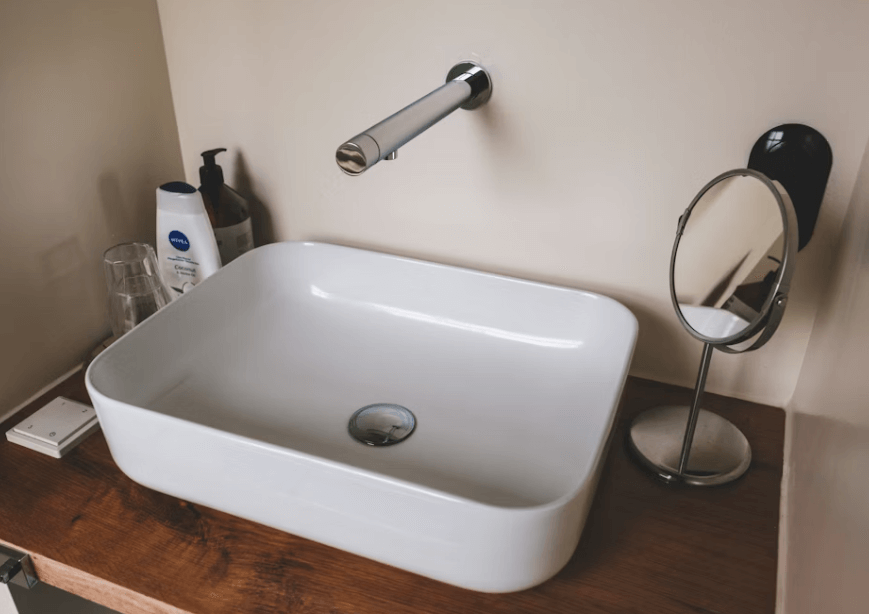 Wall mounted touchless faucet above a modern bathroom sink